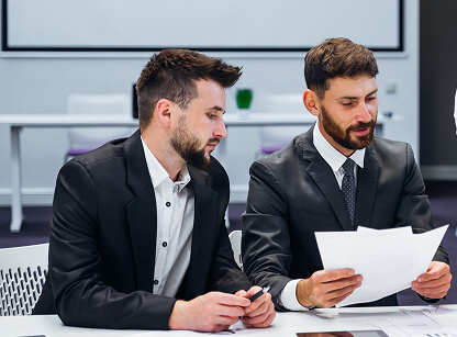 Two men in suits reviewing a document together